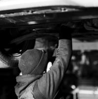 Mechanic Carrying Out Repairs Underneath Vehicle